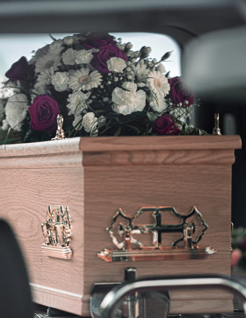 Casket adorned with white and purple flowers